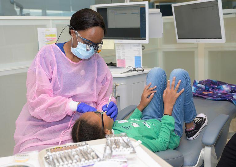 dental hygiene student with child patient