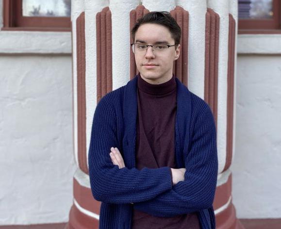 A college student standing outside by a building